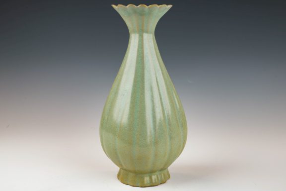 Green vase with a flared neck and ribbed surface design.